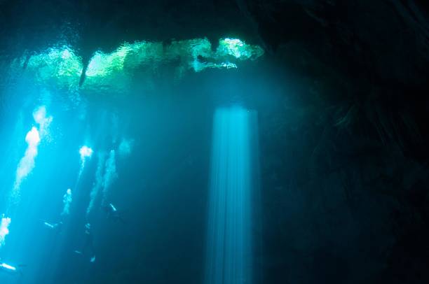 istock view of large pit cavern cenotes divers and bubbles in bright blue laser lights 7 696427452