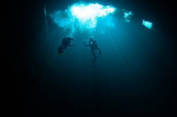 istock Divers entering at the top of the pit cave diving from below 696427666
