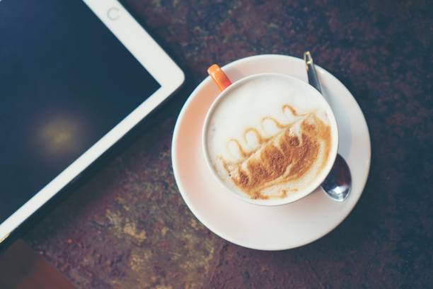 istock morning time with coffee latte art and tablet, vintage filter image 696441646