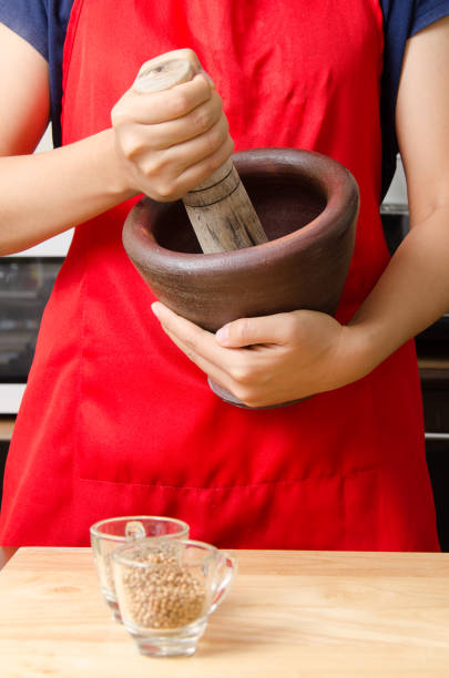 Chef pounding spices and herbs in mortar for Thai food cooking