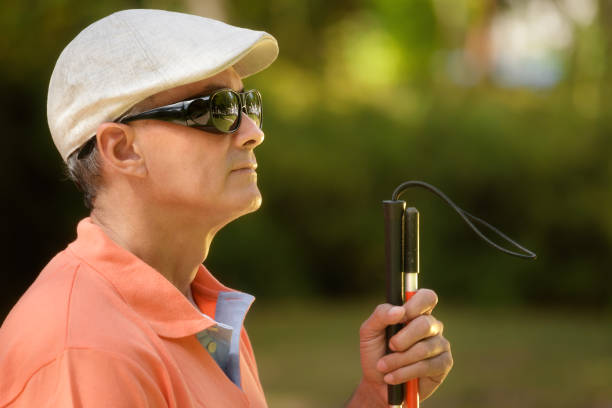 Portrait Of Blind Man Sitting In City Park"n Hispanic blind man, latino people with disability, handicapped person and everyday life. Visually impaired man with walking stick, sitting on bench in city park. Copy space"n blind persons cane stock pictures, royalty-free photos & images