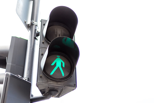 Traffic lights with the green light lit for pedestrians. Isolated on white background.