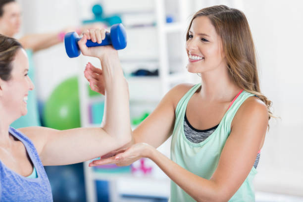 istock Friends help each other use barbell at the gym 696450090