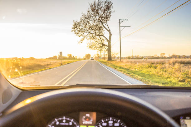 sunset drive - car steering wheel windshield speedometer foto e immagini stock