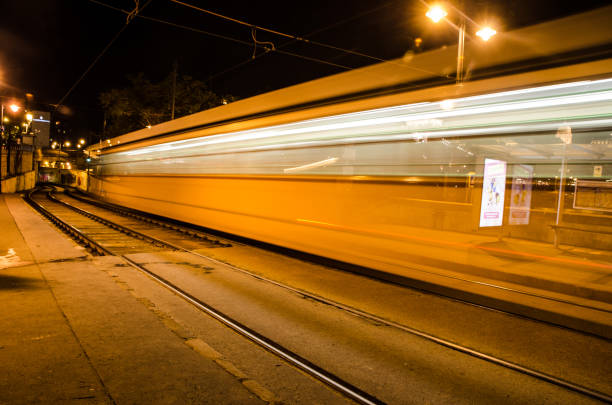 Long exposure of yellow train passing by at summer night outside in Budapest