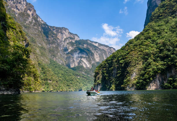 Boat with people in Sumidero Canyon - Chiapas, Mexico Chiapas, Mexico - Oct 2016: Boat with people in Sumidero Canyon - Chiapas, Mexico mexico chiapas cañón del sumidero stock pictures, royalty-free photos & images