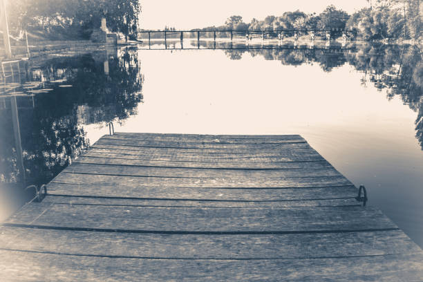 istock Old vintage photo. Empty wooden old berth on river 696464776