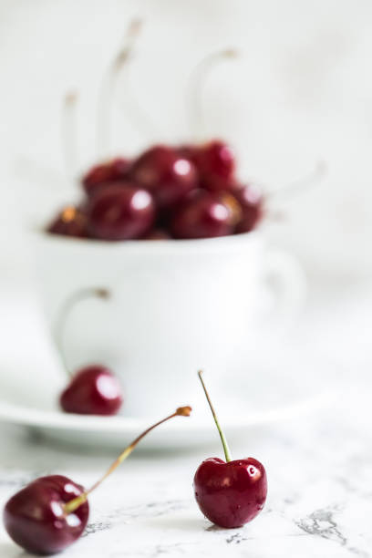 istock Ripe sweet cherry in a white mug 696471124