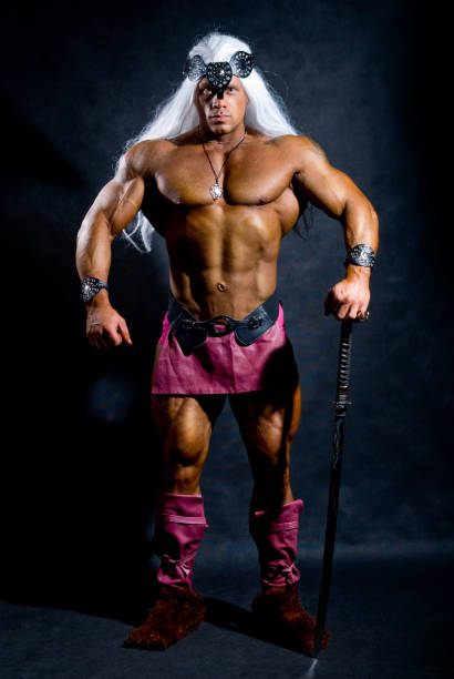 istock Muscular man in the image based on the barbarian sword. 696472162