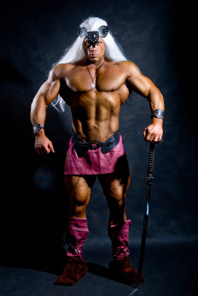 istock Muscular man in the image based on the barbarian sword. 696472166
