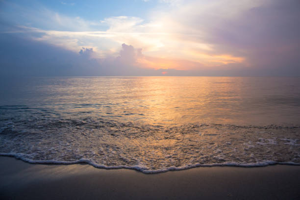 istock Beautiful sky at sunrise at the beach and waves 696480998