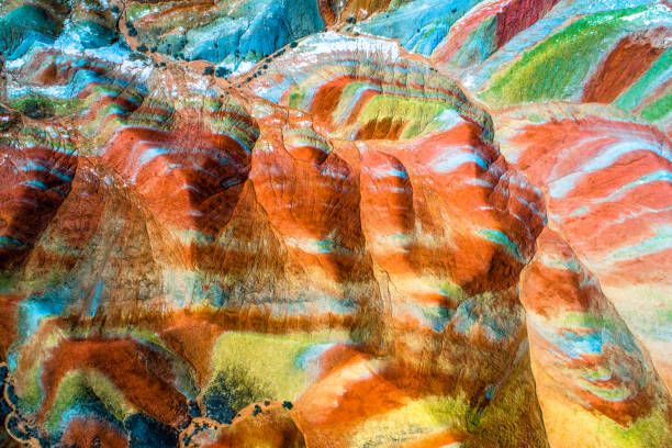 Colorful pattern on rainbow mountains Colorful Rainbow Mountains in Zhangye National Geopark; aerial top down view on sandstone hills and mountain chains covered with amazing pattern due to deposition of minerals, Gangsu, China, May 2017 zhangye danxia geopark china stock pictures, royalty-free photos & images