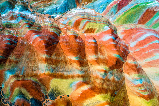 Colorful pattern on rainbow mountains Colorful Rainbow Mountains in Zhangye National Geopark; aerial top down view on sandstone hills and mountain chains covered with amazing pattern due to deposition of minerals, Gangsu, China, May 2017 danxia landform stock pictures, royalty-free photos & images