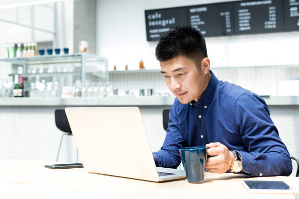 istock young asian man with laptop in modern cafe 696492522