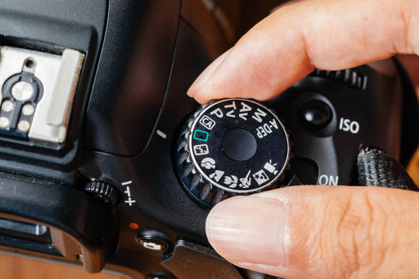 istock Auto dial mode on dslr camera with fingers on the dial 696496248