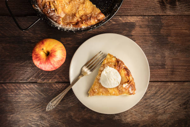 Overhead photo of piece of apple pie with ice-cream An overhead photo of a piece of a homemade apple pie with a scoop of ice cream, with the rest of the pie in a skillet, and an apple, with a place for text apple pie and ice cream stock pictures, royalty-free photos & images