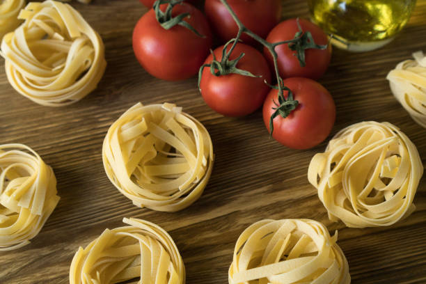 istock Pasta ingridients and spice on wooden surface. 696499470