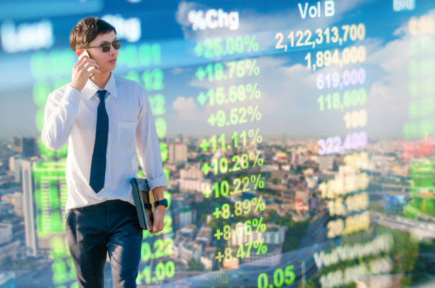 istock Young business man using laptop and digital tablet cityscape background 696500472