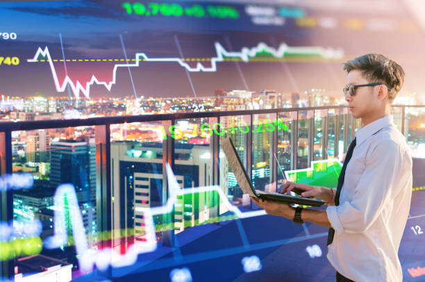 istock Young business man using laptop and digital tablet cityscape background 696500488