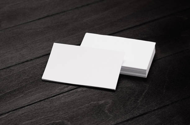 istock Blank corporate identity business card and stack on black stylish wood background with blur, template. 696503838