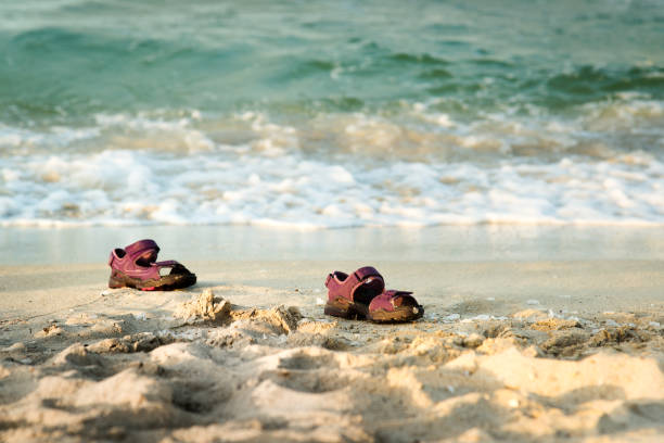 par de sandálias pequenas perdidas na praia - lost beach - fotografias e filmes do acervo