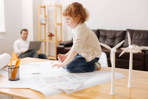 istock Funny kid sitting on his legs on the table 696517912