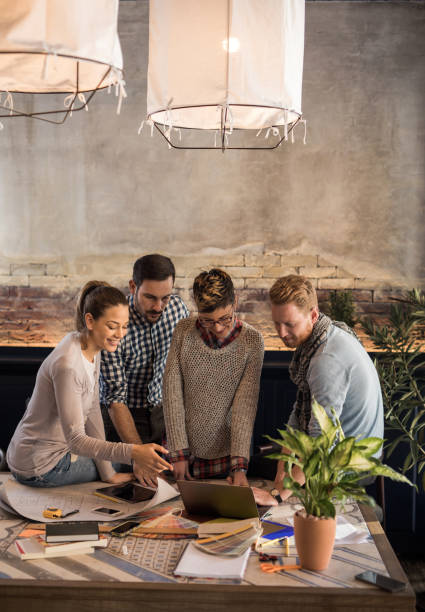 istock Team of freelance workers using laptop at casual office. 696525254
