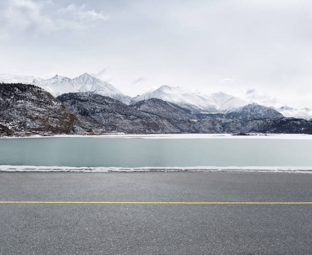 istock asphalt road and snow lake 696525834