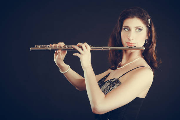 istock Woman playing transverse flute on black. 696532206