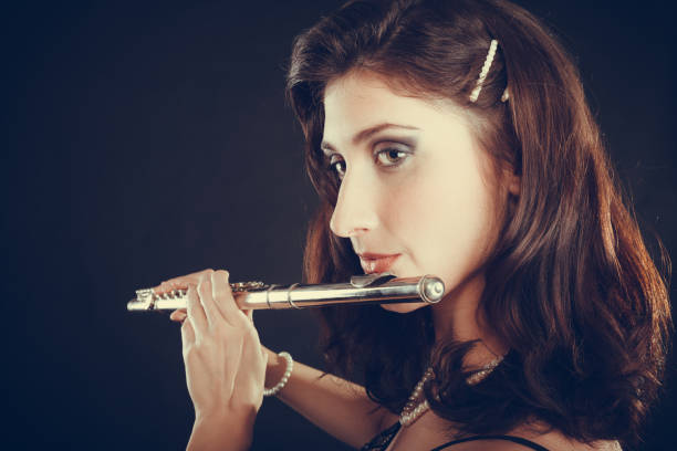 istock Woman playing transverse flute on black. 696532584