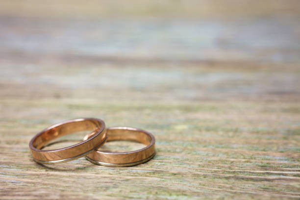 istock wedding rings on wood 696533098