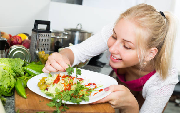 istock girl at kitchen preparing salad 696533112
