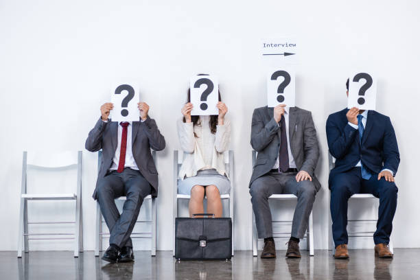 istock businesspeople sitting in queue and waiting for interview, holding question marks in office, business concept 696536756