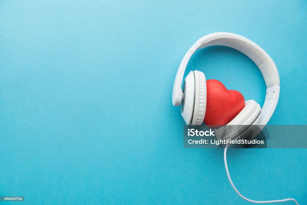 Weiße Kopfhörer mit roten Herzen zu unterzeichnen, in der Mitte auf blauem Untergrund - Lizenzfrei Musik Stock-Foto