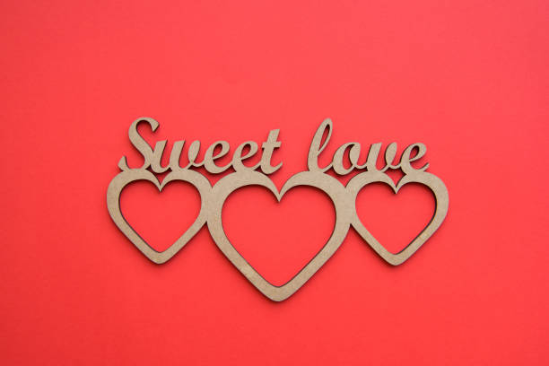 istock Hearts with Sweet love cardboard stencil on red surface 696540308