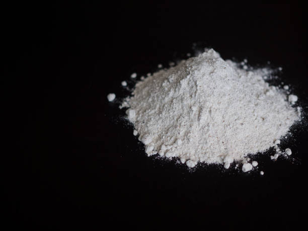 istock Wholemeal flour in pile isolated on black 696557206