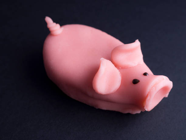 istock Marzipan pig cake isolated on black background 696565128