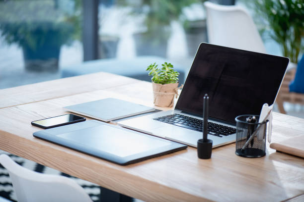 istock laptop with blank screen and graphics tablet with smartphone on wooden tabletop at office 696567170