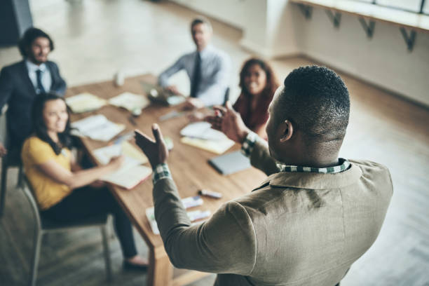 With great leadership comes great responsibility Rearview shot of an unidentifiable businessman giving a presentation to his colleagues in the office styles stock pictures, royalty-free photos & images