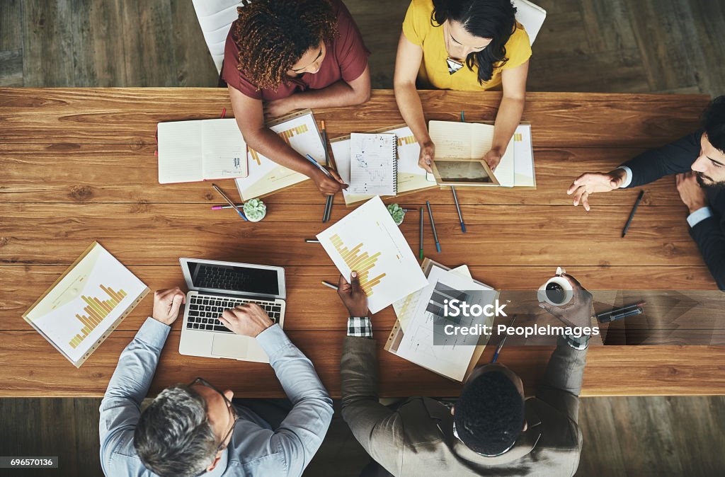 Birds-eye view of business High angle shot of a team of businesspeople meeting around the boardroom table in the office Office Stock Photo