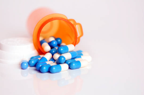 Medicine in light protected bottle. Capsules in orange bottle; Refill prescription concept.
