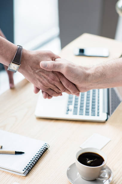 istock Business partners shaking hands at office 696593404