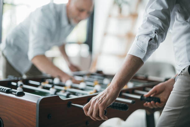 istock Senior business colleagues playing foosball at office 696594492
