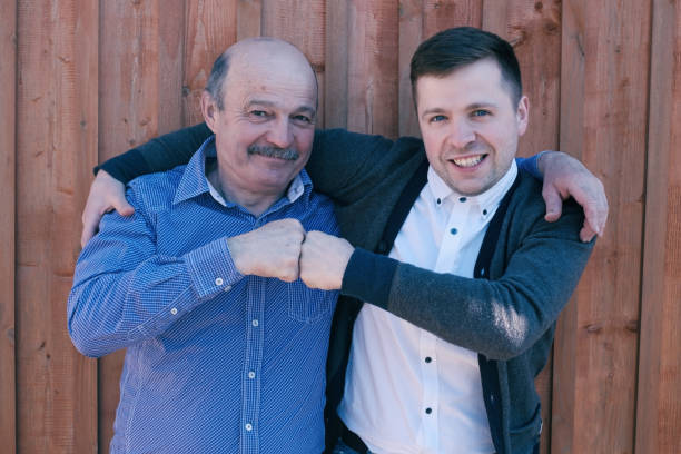 istock Father and son on wooden background 696597408