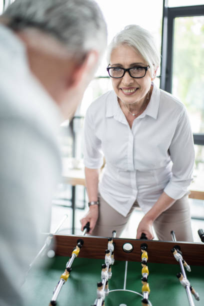 istock Senior business colleagues playing foosball at office 696597718