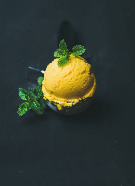 istock Refreshing Mango sorbet ice cream scoop in scooper, copy space 696601602