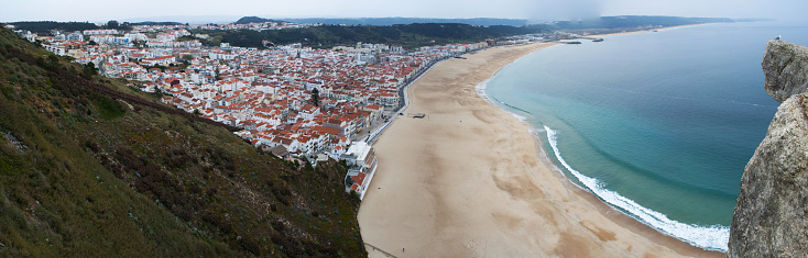 Nazaré, Portugal - March, 30, 2012: the Atlantic Ocean and view of a rock on the top of Sitio, the old neighborhood of the town of Nazare