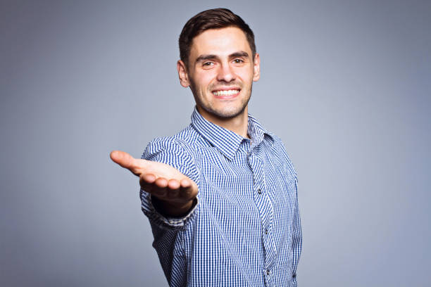 istock Business man showing something on gray background 696605916