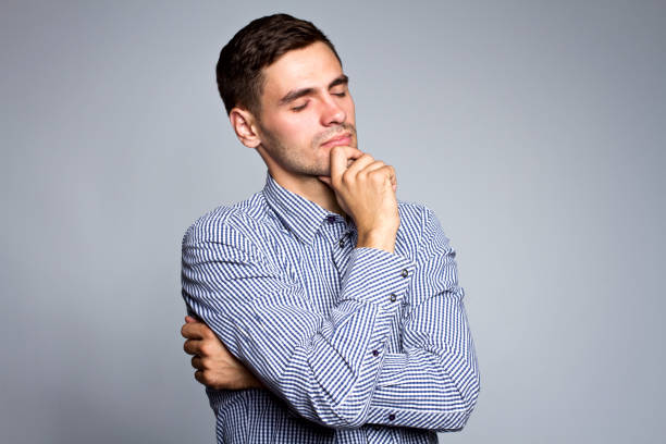 istock Portrait of thinking businessman on gray background with closed eyes, thinking about problems. 696608772