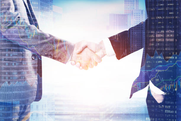 istock Businessmen s handshake and a city 696612246